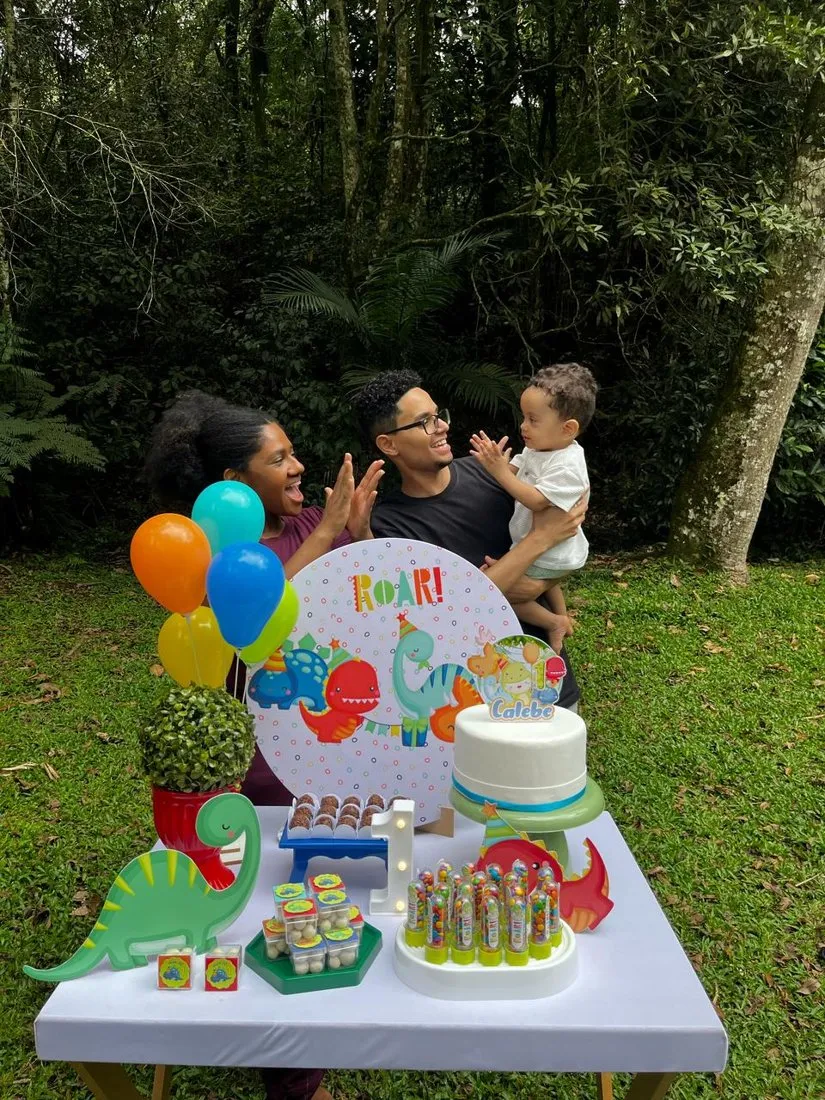 Família comemorando o primeiro aniversário com a mesa decorada montada em um parque