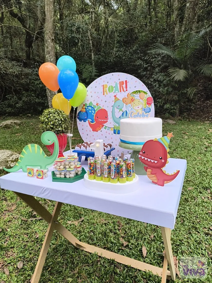 Mesa de festa com tema de dinossauros montada ao ar livre